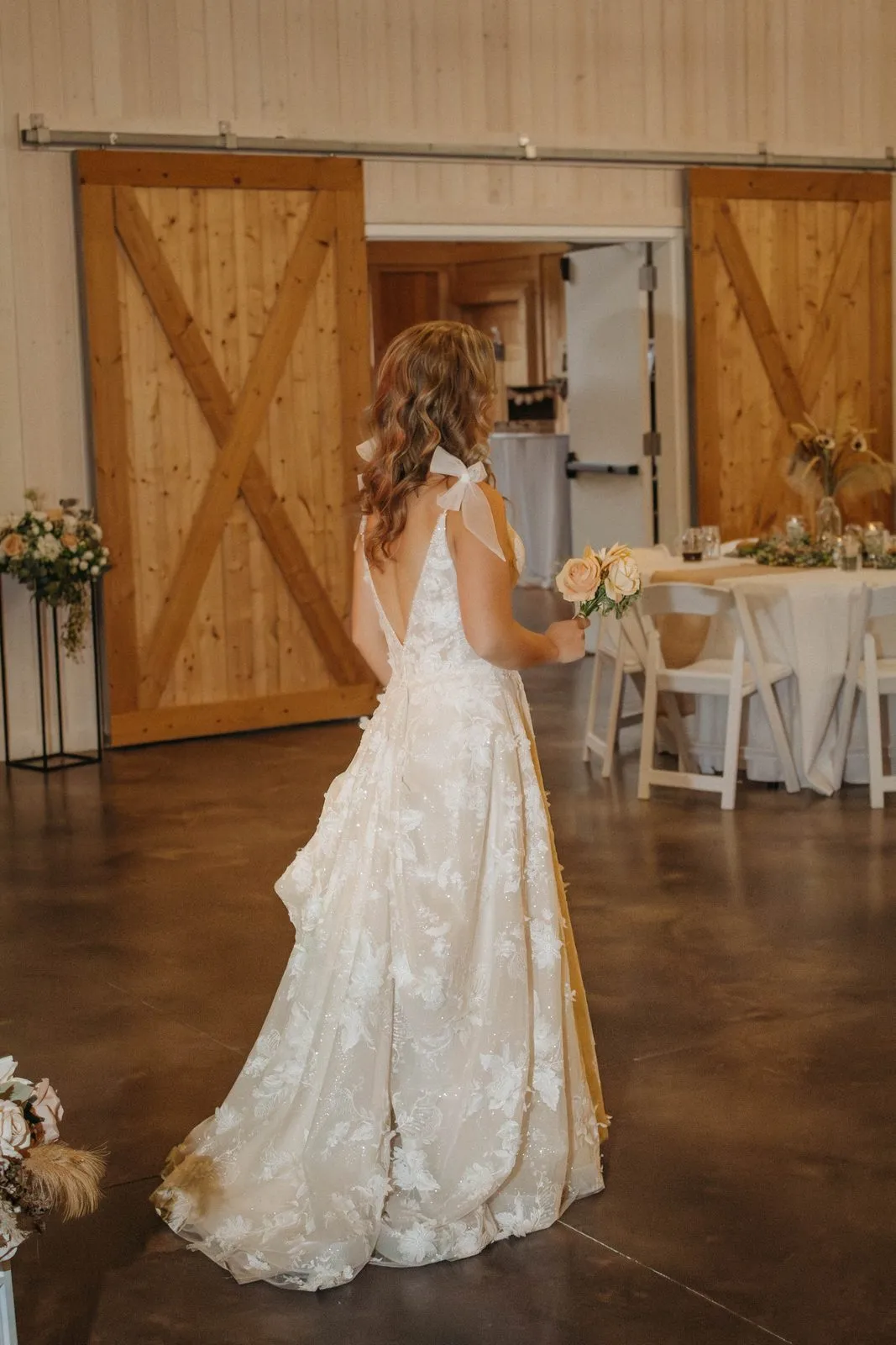Bride entering the barn through the open wooden doors at The Heritage Barn in Conover, NC