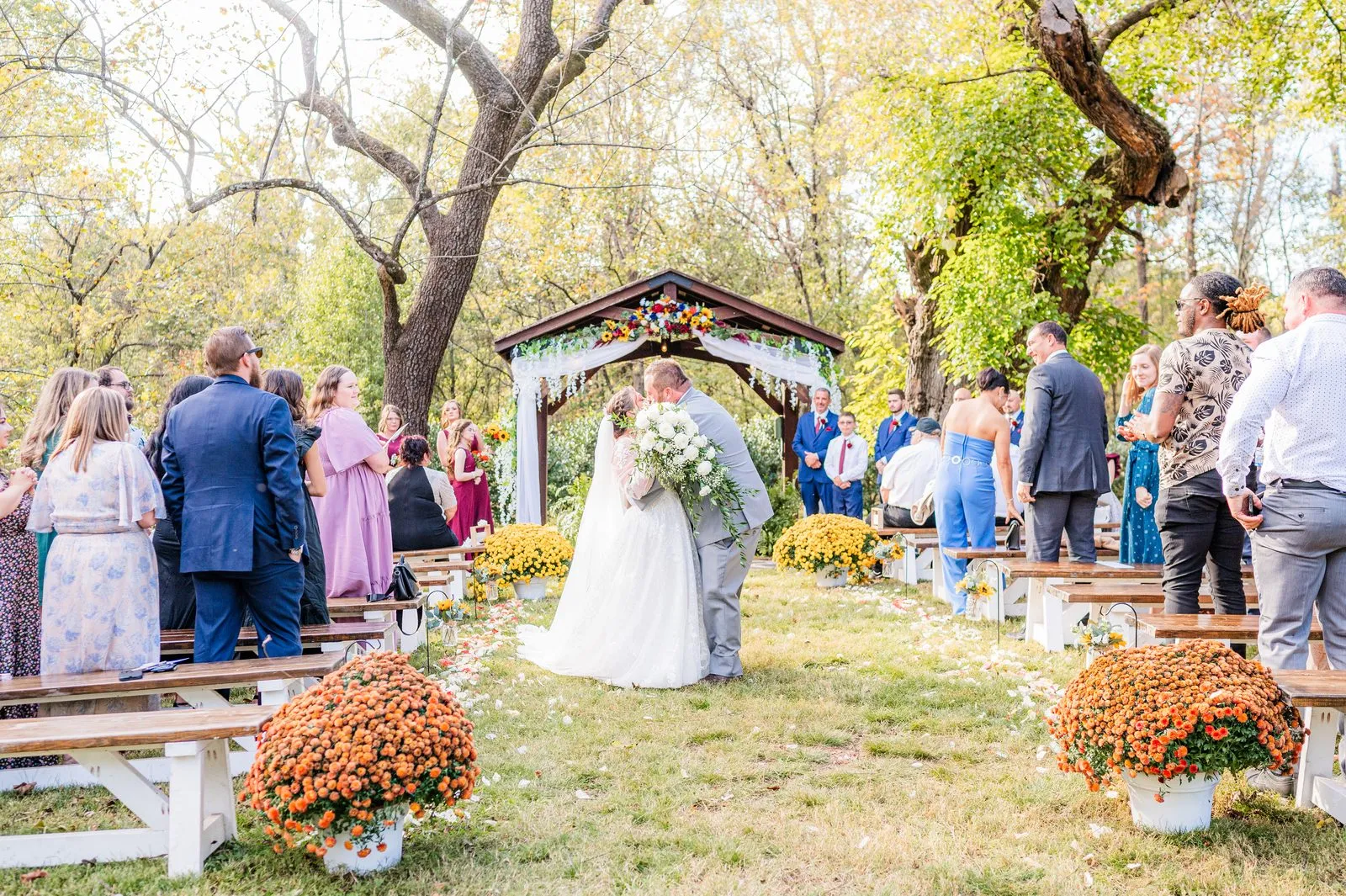 Autumn ceremony beneath the wooden pavilion with floral garlands at The Heritage Barn