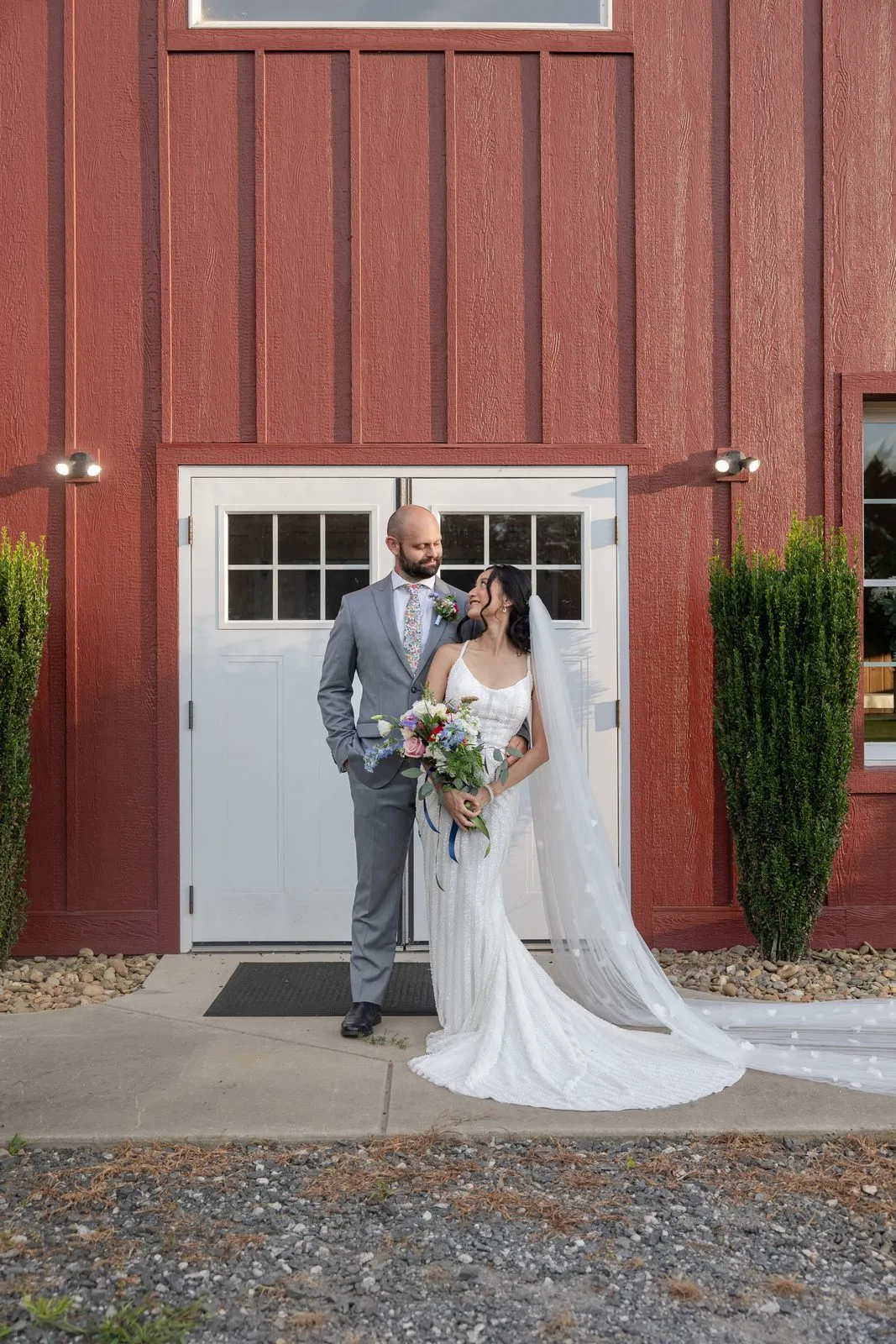 Newlyweds at the white barn entrance doors at The Heritage Barn