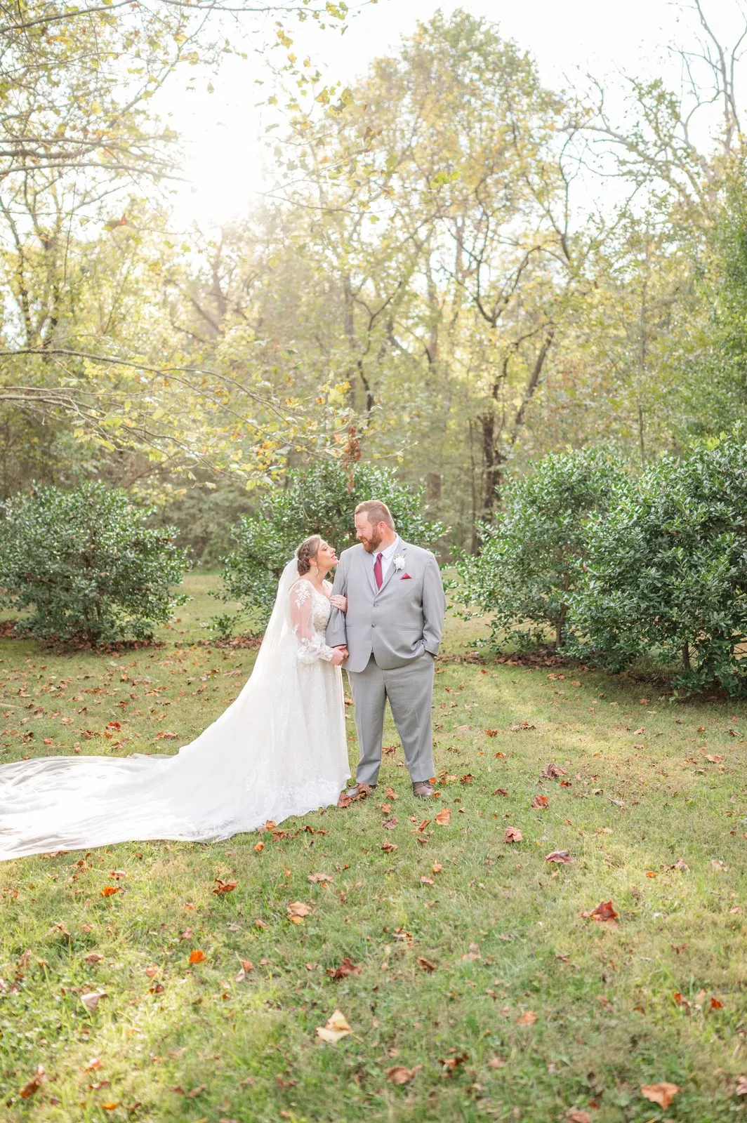 Bride and groom with a flowing veil in the field at The Heritage Barn wedding venue near Hickory, NC