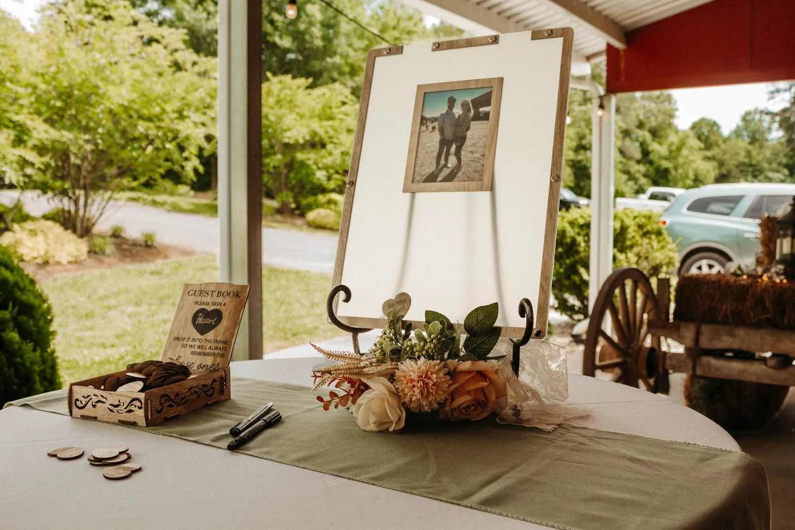 Styled welcome table with a mirror sign and florals at the entrance to The Heritage Barn