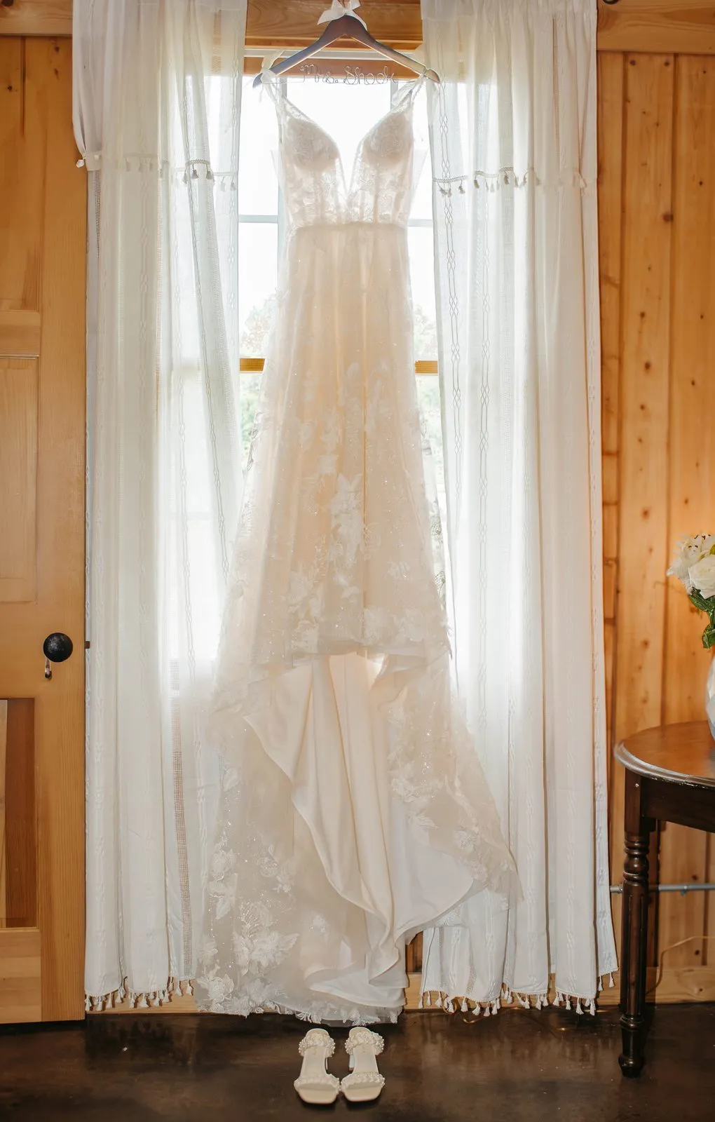 Wedding dress hanging in the window light at The Heritage Barn in Conover, NC