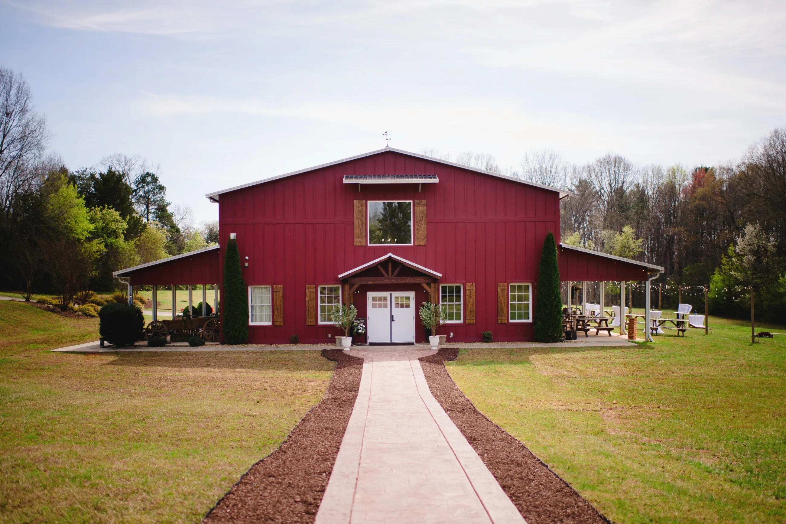 The Heritage Barn red event barn at the end of a tree-lined walkway on 30 acres in Conover, NC
