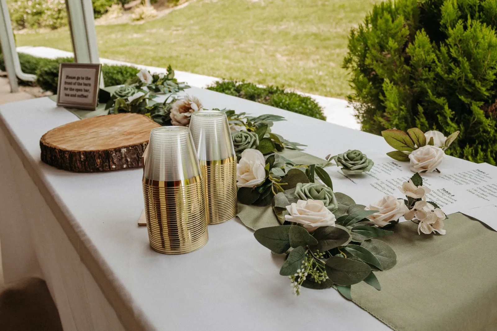 Long table dressed with a fresh greenery garland and candles at The Heritage Barn