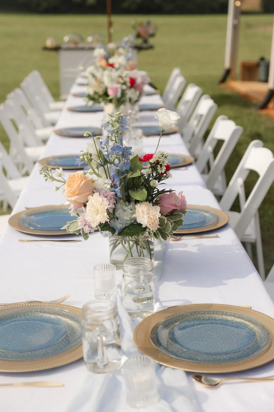 Long banquet table with a colorful floral runner at The Heritage Barn